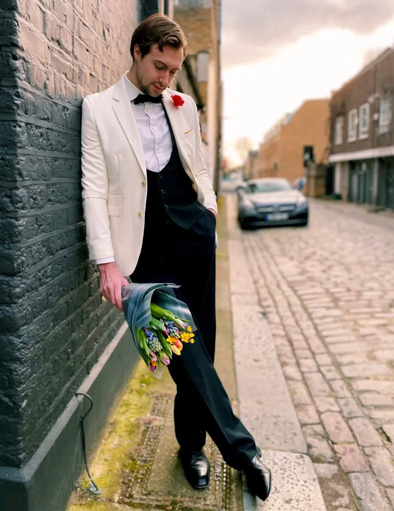 Rote Boutonnière Nelke aus Seide im Knopfloch des weißen Dinnerjackets