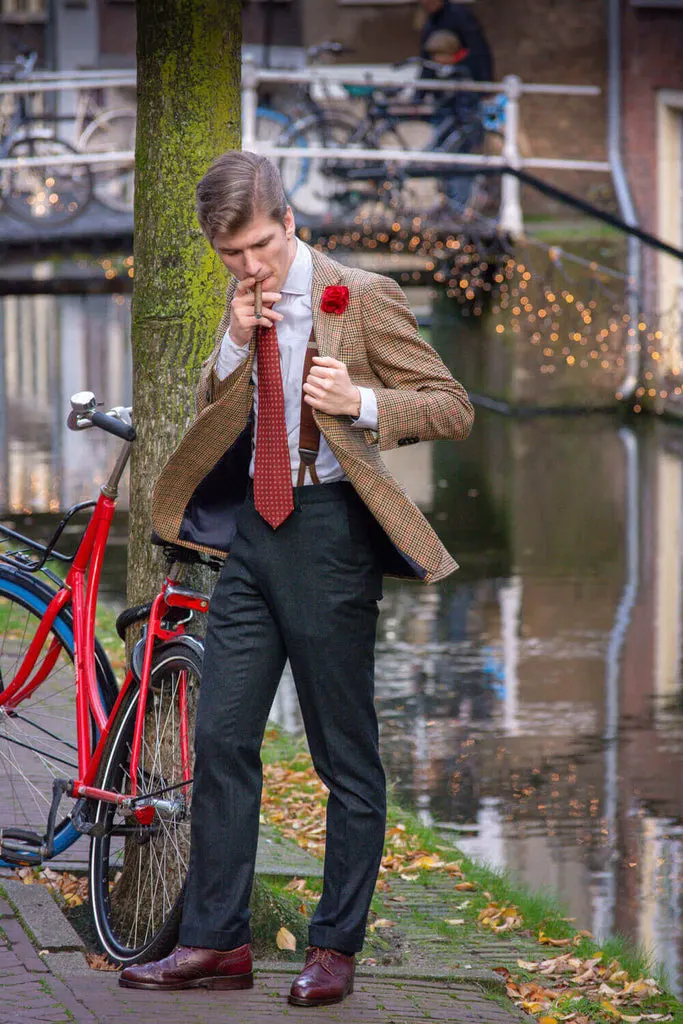 Jost Bom mit roter Boutonniere, Tweedsakko und Hosenträgern in Delft