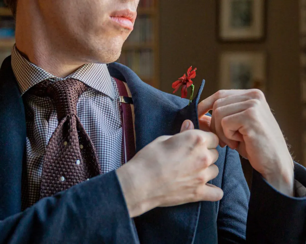 Wie wird eine Boutonnière am Revers befestigt?
